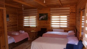 Eine Hütte mit zwei Betten, einem kleinen Tisch und einem Stuhl.