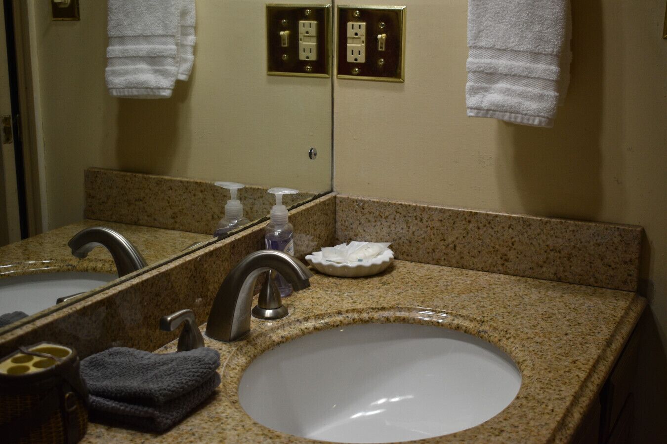 A bathroom with two sinks, a mirror, and a towel rack.