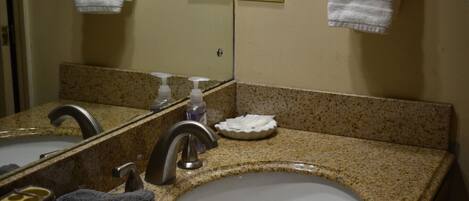 A bathroom with two sinks, a mirror, and a towel rack.