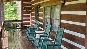 Eine Holzhütte mit Veranda, Holzfassade und Tisch mit Stühlen.