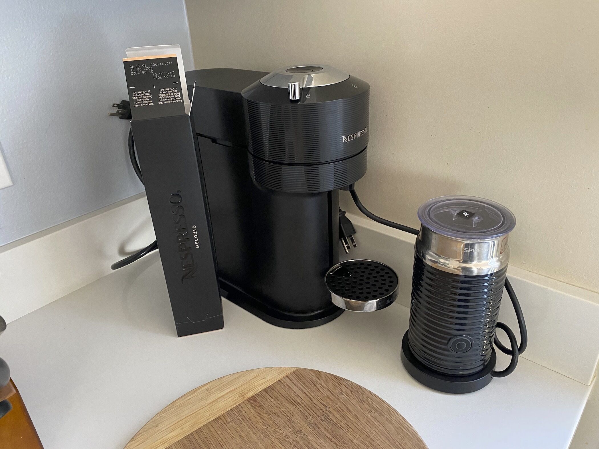 Una cafetera Nespresso sobre una encimera de cocina, con un dispensador de cápsulas y un depósito de agua.
