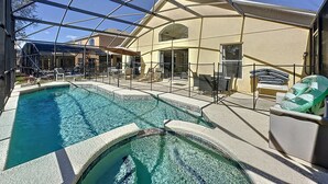 Ein Poolbereich mit Glasveranda, Liegestühlen und einer überdachten Terrasse.