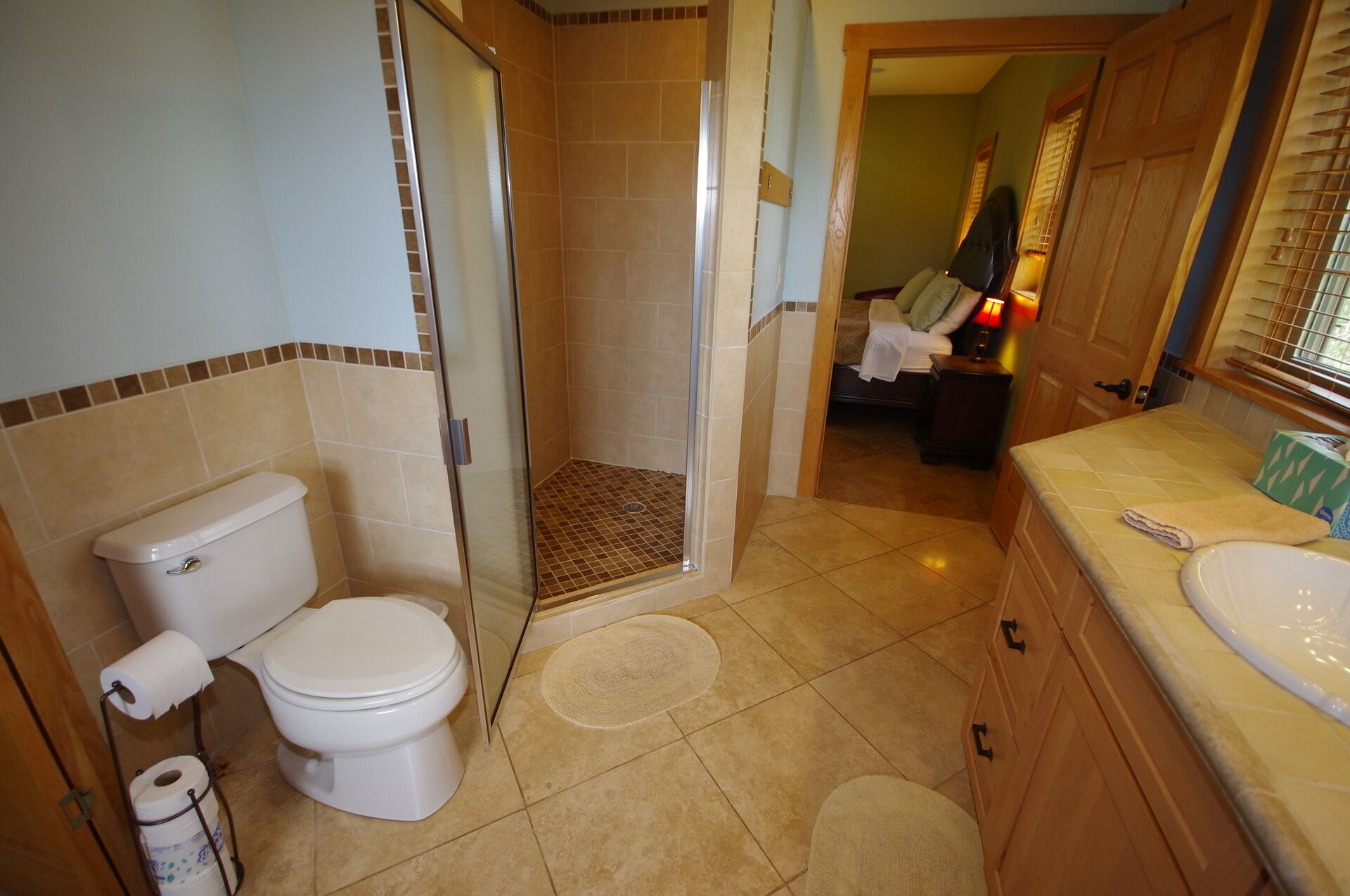 A bathroom with a toilet, shower, and sink.