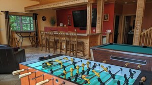 Een tafelvoetbaltafel in een ruimte met houten wanden en een rode accentmuur.