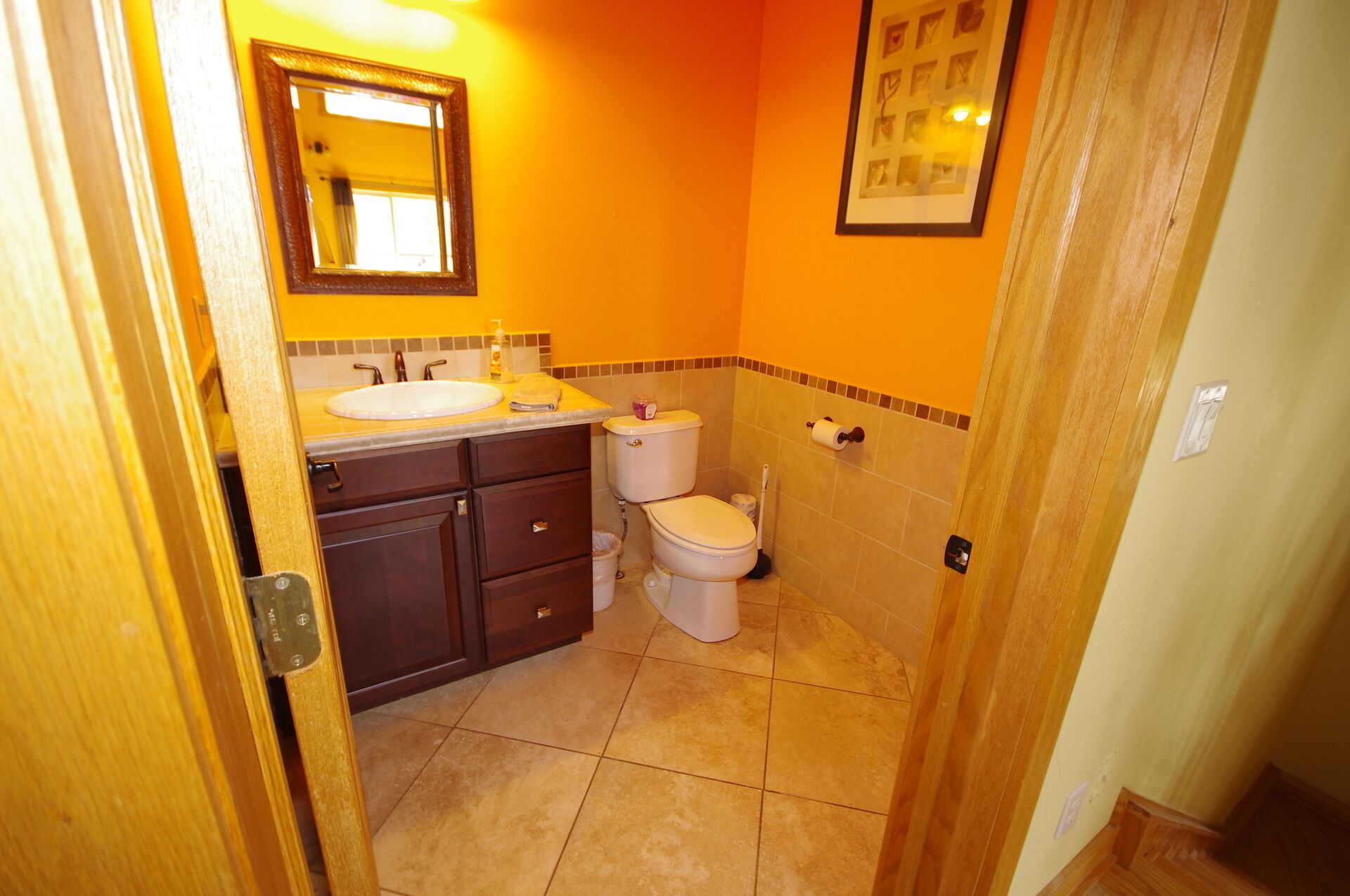 Un baño con lavamanos, inodoro y espejo.