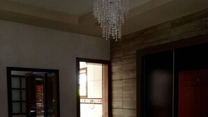 Ein Schlafzimmer mit einem großen Bett, einem Spiegel, einer Chandelieber und einem Kleiderschrank.
