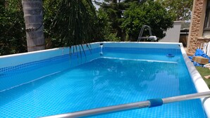 A rectangular swimming pool with a tiled edge and a ladder leading into it. - Assaf's Cabin (Mateh Asher)