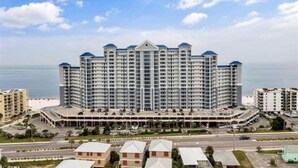 A large, multi-story hotel with a central atrium and a parking garage. - Lighthouse 1017 1 Bedroom Condo by RedAwning (Gulf Shores)
