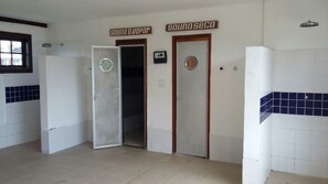 A bathroom with two doors labeled 'sound vapor' and 'suna seca'. - Casa Condomínio Geribá (Búzios)