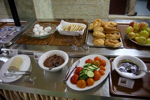A buffet with various food items including bread, fruits, and vegetables. - St. Vincent Guest House - Bethlehem (Bethlehem)