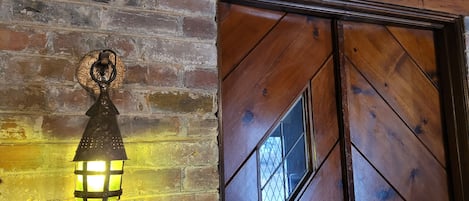 Una puerta de madera con diseño de rombos y un ventanal pequeño.