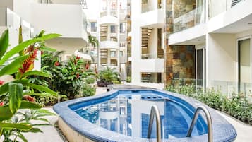 Una piscina al aire libre, sillones reclinables de piscina