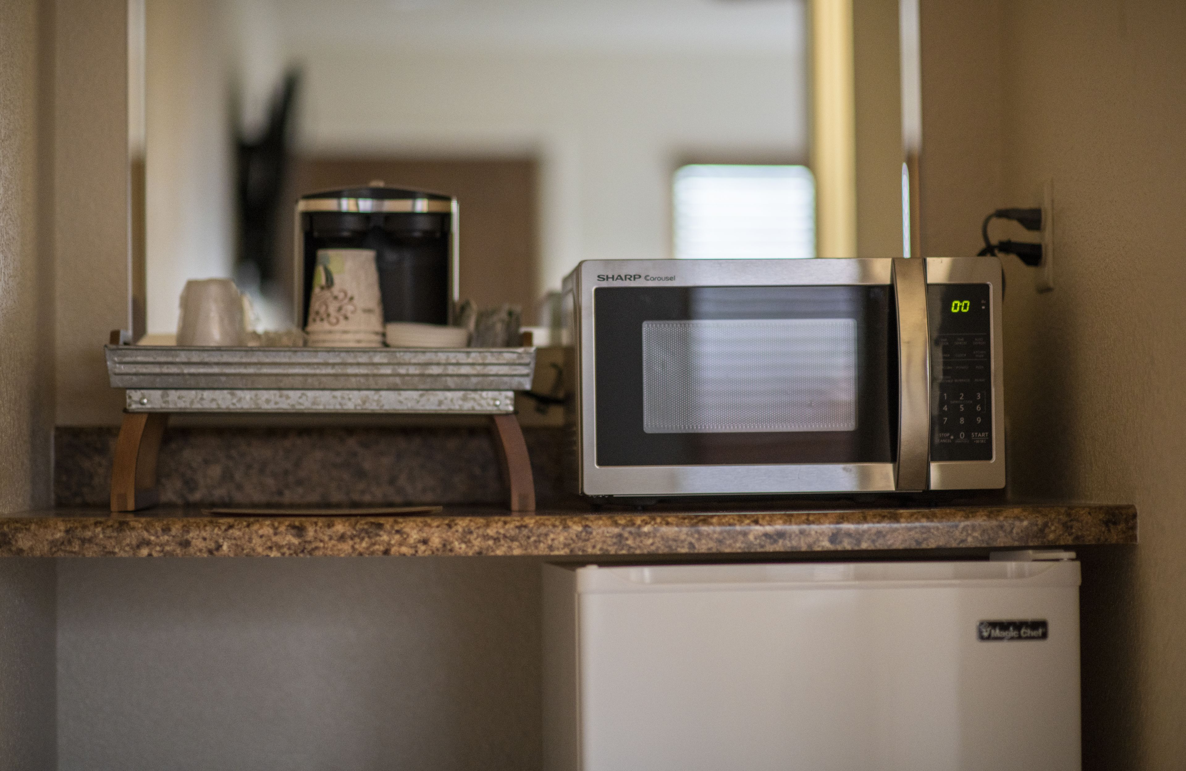 Une cuisine équipée d’un four à micro-ondes, d’une machine à café et d’un réfrigérateur.
