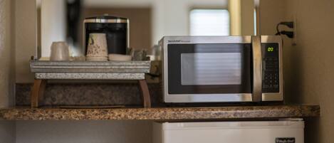 Une cuisine équipée d’un four à micro-ondes, d’une machine à café et d’un réfrigérateur.