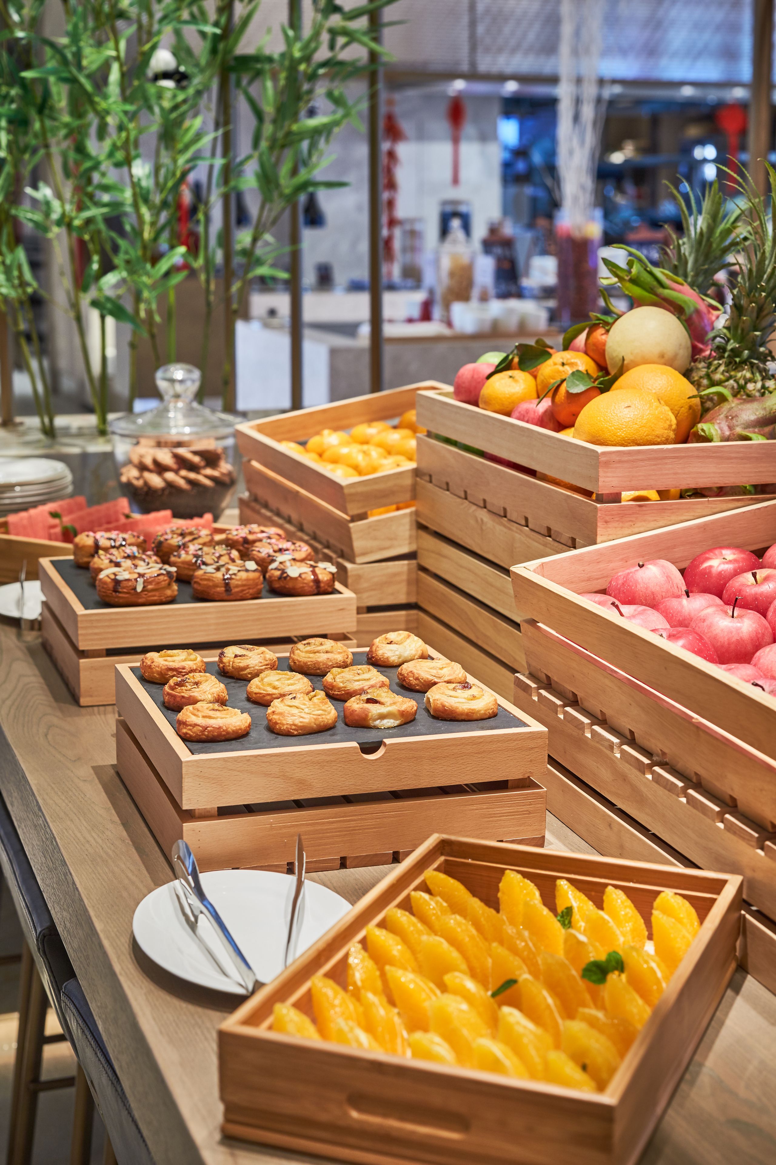Una mesa de buffet con diversas opciones de comida, incluyendo frutas, pasteles y postres.