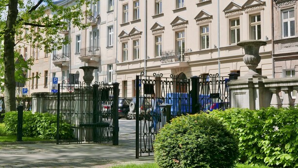 Un edificio clásico con ventanas simétricas y una puerta de acceso central.