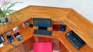 A modern office space with a wooden desk, multiple chairs, and a glass partition. - Pousada Cana Caiana (Paraty)
