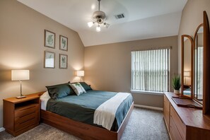 A bedroom with a bed, nightstands, a dresser, a ceiling fan, and framed botanical prints on the wall. - LUXURY HOME! 5 mins to Cowboy Stadium; 9 mins to Six Flags; 15 mins to DFW (Arlington)
