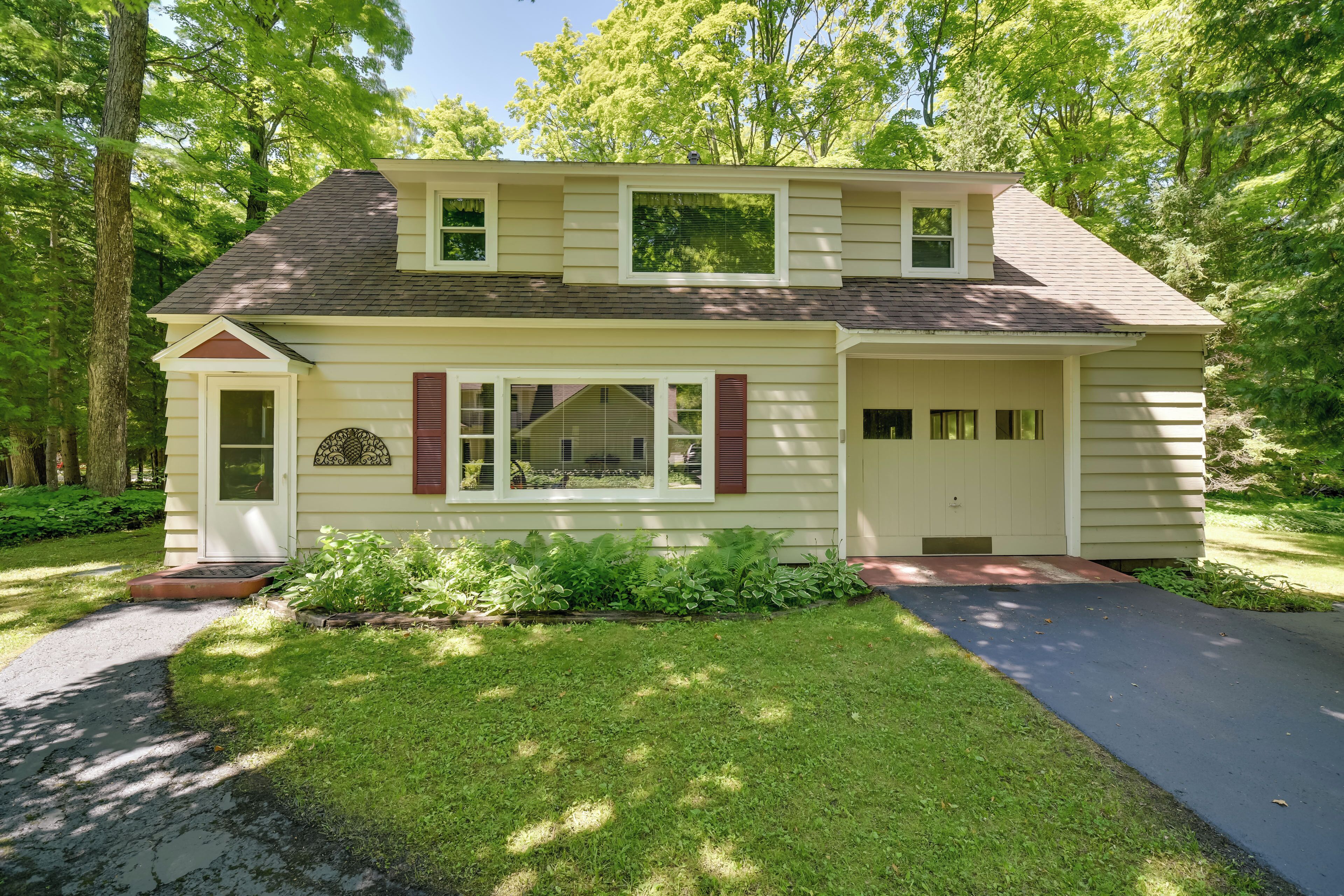 A two-story house with a front porch, a garage, and a well-maintained lawn.