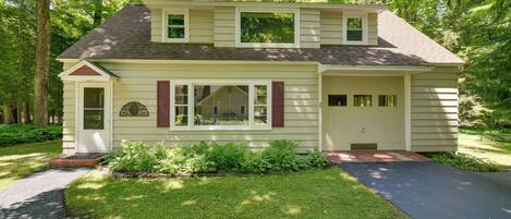 A two-story house with a front porch, a garage, and a well-maintained lawn.
