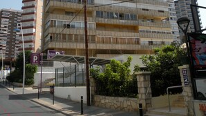 A multi-story residential building with balconies, a parking sign, and a street view. - PRINCIPADO CENTRO (4 BEDROOMS) (Benidorm)