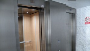 An elevator with a metallic finish, a wooden interior, and a marble wall with a no smoking sign. - PRINCIPADO CENTRO (4 BEDROOMS) (Benidorm)