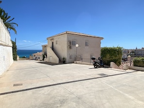 A building with a tiled roof, a staircase leading to the entrance, and a scooter parked in front. - Litoral Burriana Apartment by Casasol (Nerja)
