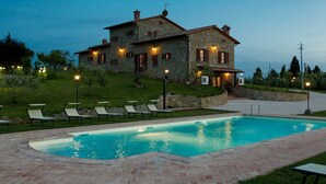 A stone house with a swimming pool, outdoor seating, and a well-lit garden. - Villa Farneta - Villa with private pool (Cignano)