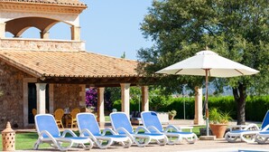 Ein Poolbereich mit Liegestühlen und einer Pergola.