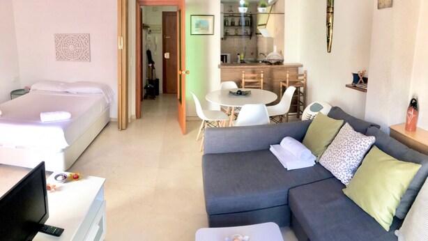 A compact living space with a bed, a sofa, a dining table with chairs, and a kitchenette. - SAN ROC APARTMENT R035 (Benidorm)