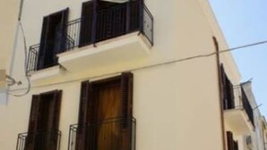 A multi-story building with balconies, a streetlight, and a door.