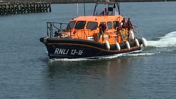 Una barca con la targa RNLI 13-16 che naviga su acque calme.