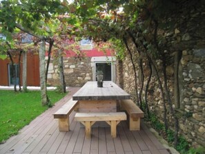Situated on a deck, this picnic table offers a comfortable seating area with a stone wall and wooden fence.