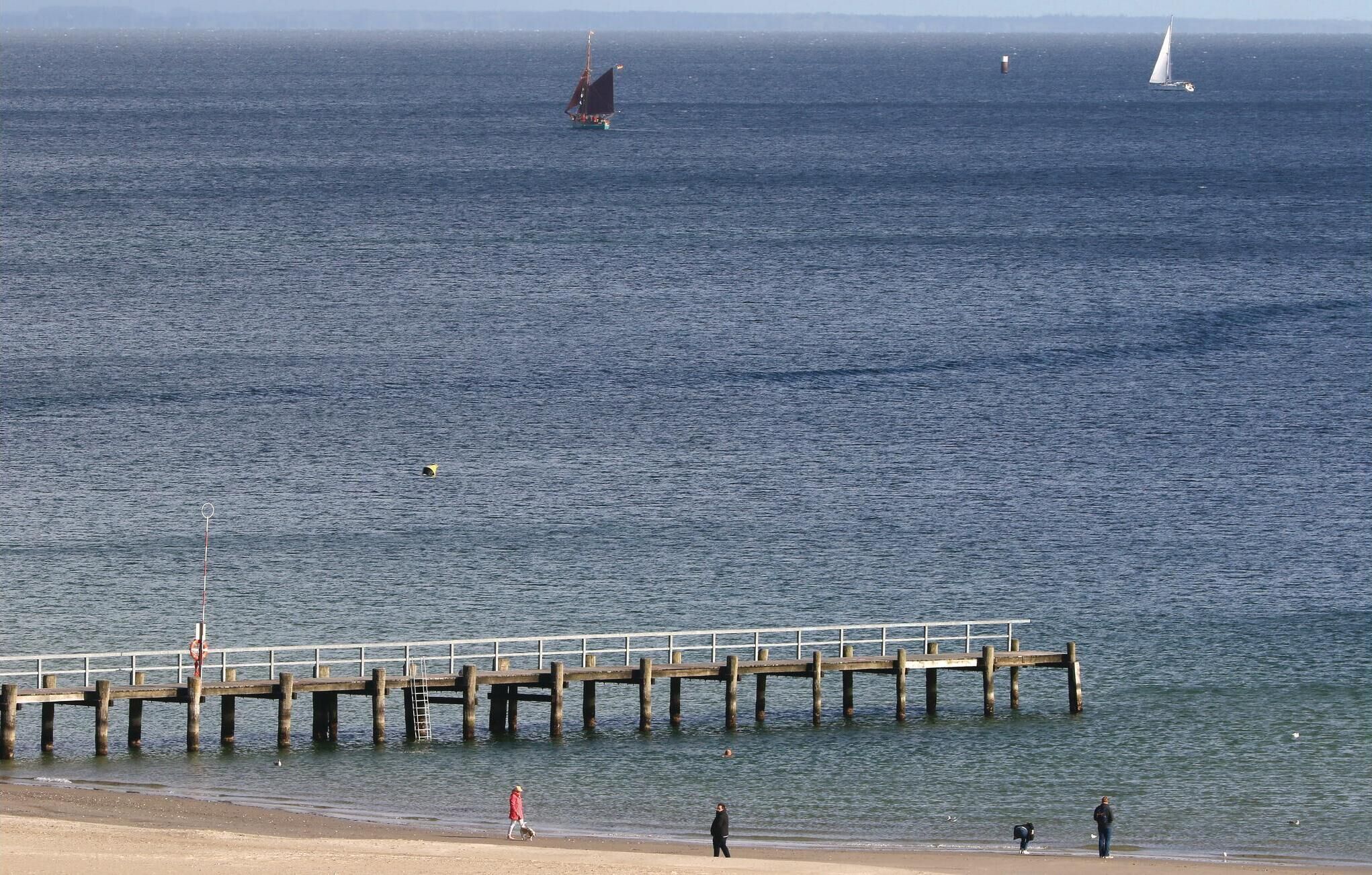 A pier extending into calm waters with a clear sky.