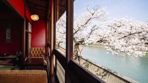 A traditional Japanese room with tatami flooring, a low wooden table, and a cushioned bench. - asanogawa (Kanazawa)