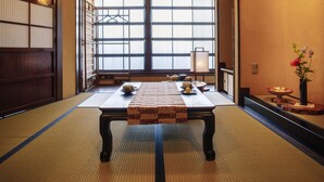A traditional Japanese room with tatami flooring, a low table with tea set, and sliding doors. - asanogawa (Kanazawa)