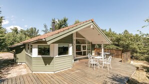 A cabin with a deck, large windows, and a covered outdoor seating area. - Gorgeous home in Aakirkeby (Aakirkeby)