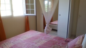 Un dormitorio con cama, ventana y puerta.