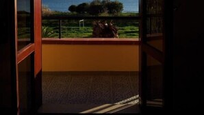Ein Zimmer mit Blick auf das Meer durch ein großes Fenster.