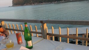 Ein Tisch für zwei, gedeckt mit Speisekarte, einer Weinflasche und einem Smartphone.