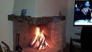 Ein Wohnzimmer mit Kamin, Fernseher und Umzugskartons.