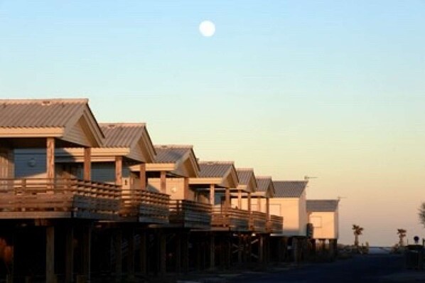 A row of wooden beach huts with a clear sky and a moon in the background. - ☆Alaric Chalet & Jacuzzi☆ Beachfront ☆ On the beach ☆ Ocean view ☆ Air conditioning ☆ 4 bedrooms (Gruissan)