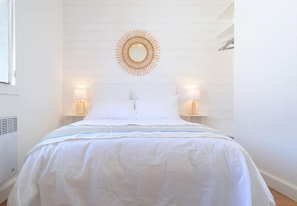 A neatly made bed with white bedding and a blue stripe, two bedside lamps, and a circular mirror on the wall. - ☆Alaric Chalet & Jacuzzi☆ Beachfront ☆ On the beach ☆ Ocean view ☆ Air conditioning ☆ 4 bedrooms (Gruissan)