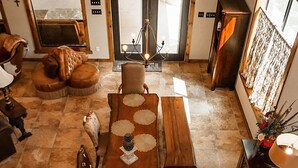 A spacious living area with a long wooden dining table, comfortable seating, and a large mirror reflecting the room.