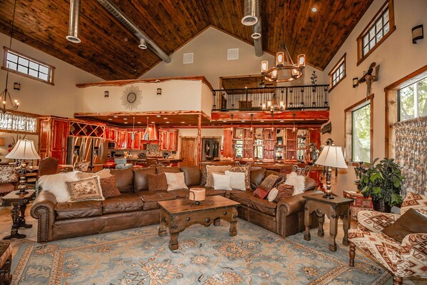 A spacious living room with leather sofas, a coffee table, and a patterned rug. - Porter's Tree Haus, Private Riverfront @Vacation Frio River Sleeps 28-32 (Concan)