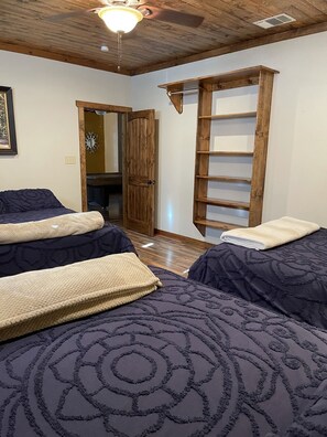 A bedroom with two beds, a wooden ladder, a ceiling fan, and a door leading to another room. - Porter's Tree Haus, Private Riverfront @Vacation Frio River Sleeps 28-32 (Concan)