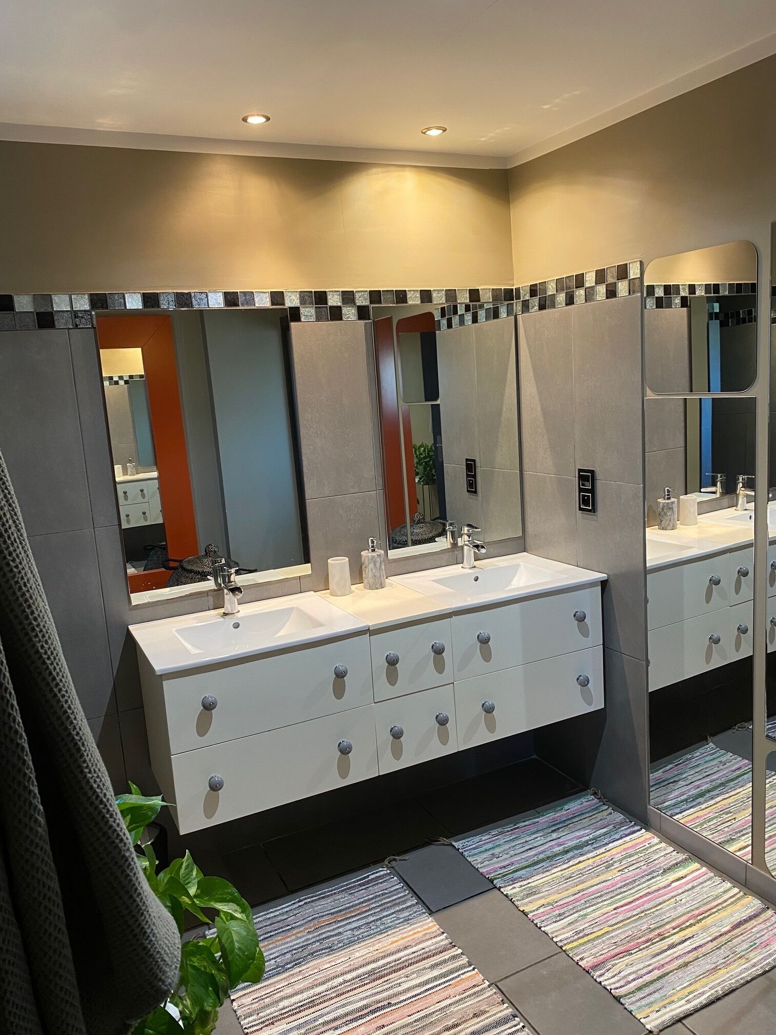 Un bany modern amb un gran lavabo, dues aixelles i un mirall.