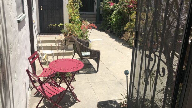 A patio with a table and chairs, a gate, and potted plants. - LARGE STUDIO, IN GREAT NEIGHBORHOOD,PET FRIENDLY, PLENTY OF PARKING (Long Beach)