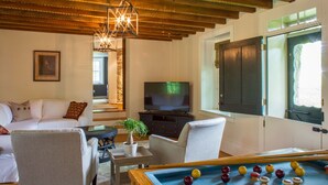 Una sala de estar con mesa de billar, televisor y un rincón de estar acogedor.