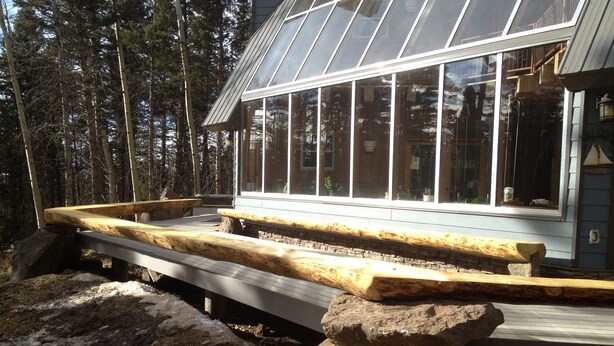 A modern building with large windows and a wooden deck. - Ski in Ski Out From 10,000' Where Living in the Mountains is all it Should be (Angel Fire)